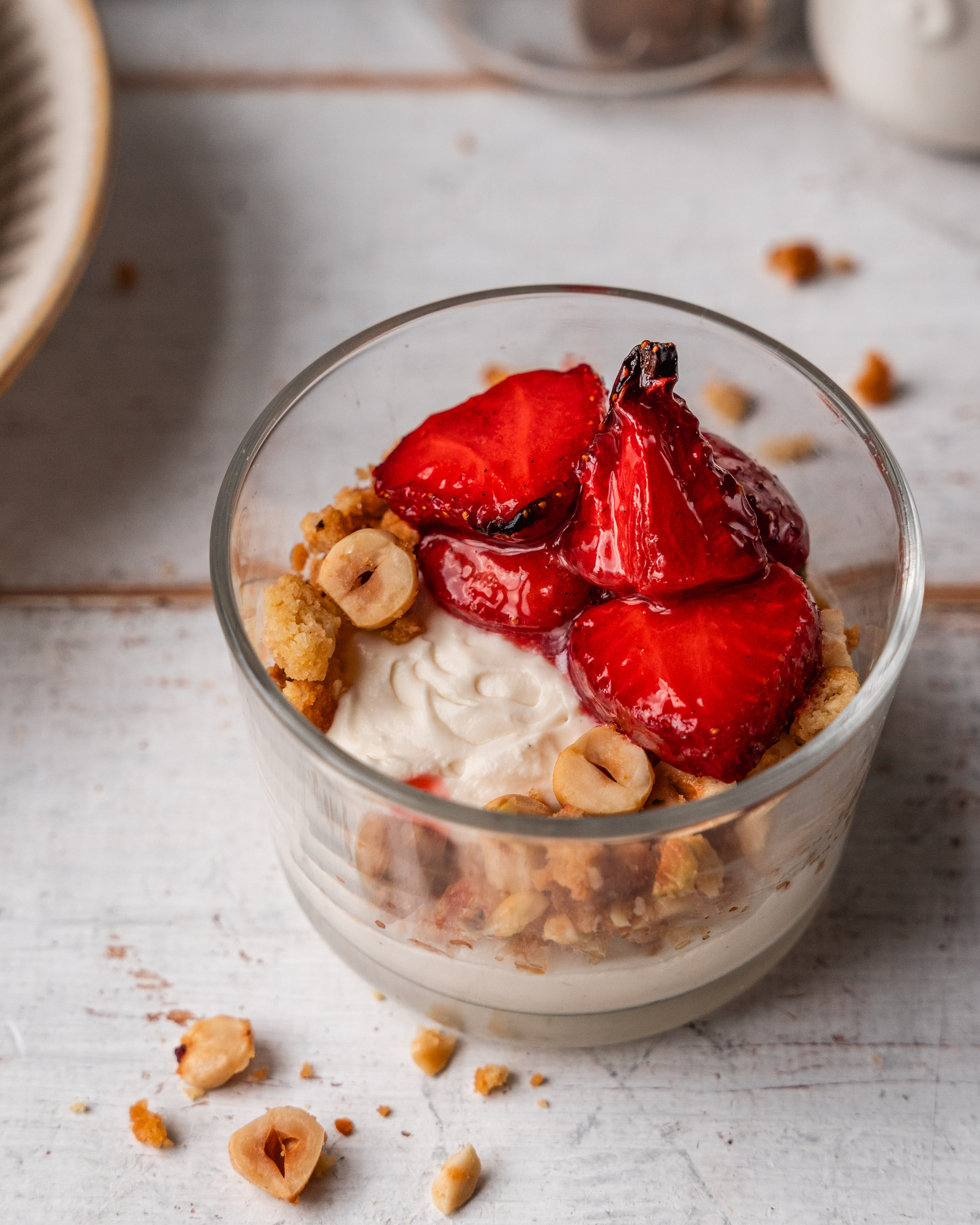 Whipped cheesecake with air fryer biscuit crunch and roasted berries in a glass ramekin.